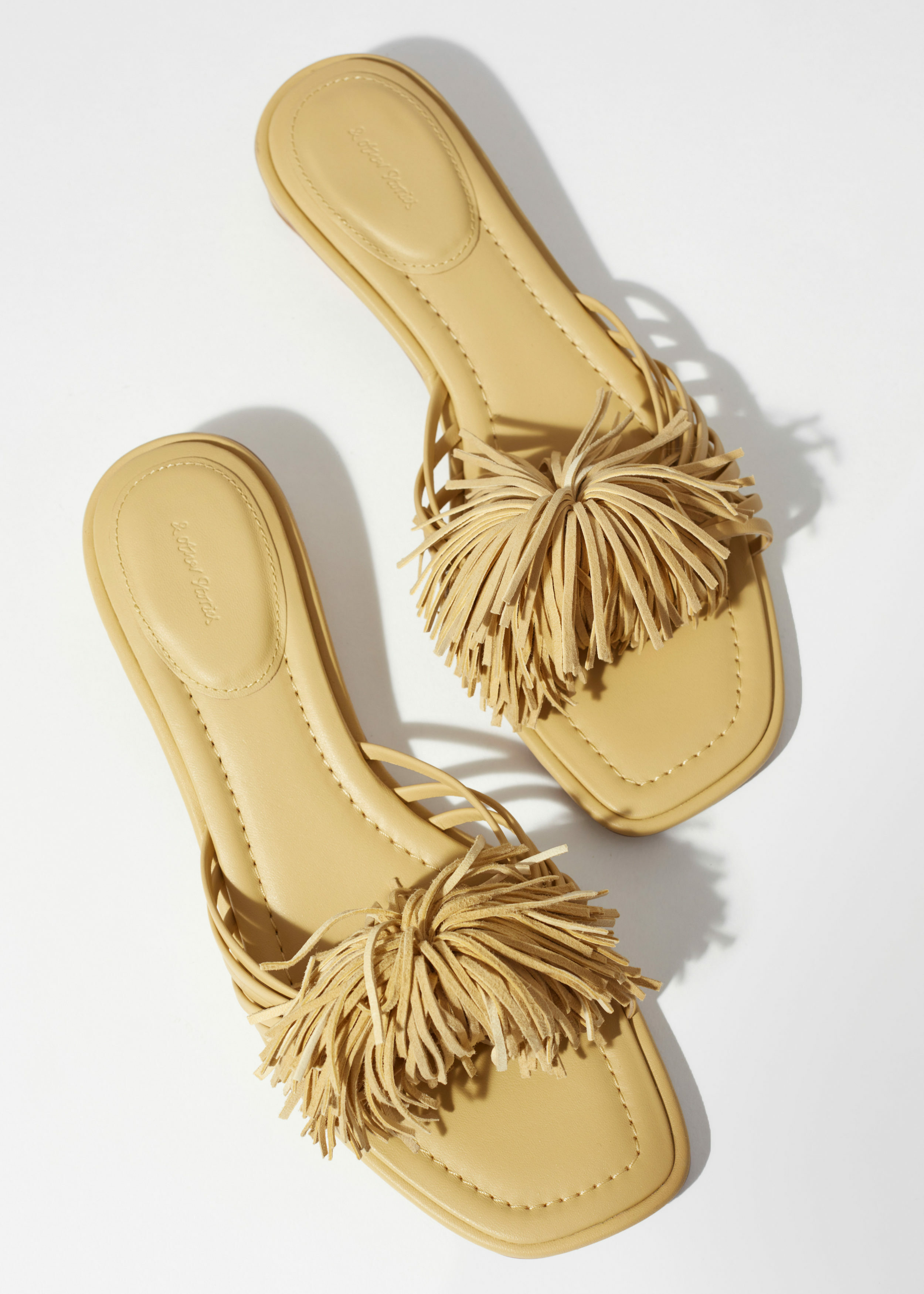 앤아더스토리즈 태슬 레더 슬라이드의 라이트 옐로우컬러 Detail입니다.