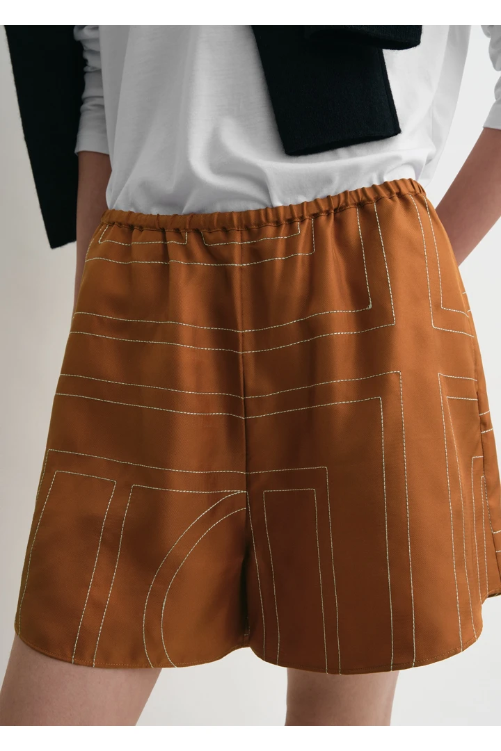 TOTEME 모노그램 실크 PJ 쇼츠 테라코타의 테라코타컬러 4번쨰 이미지입니다.